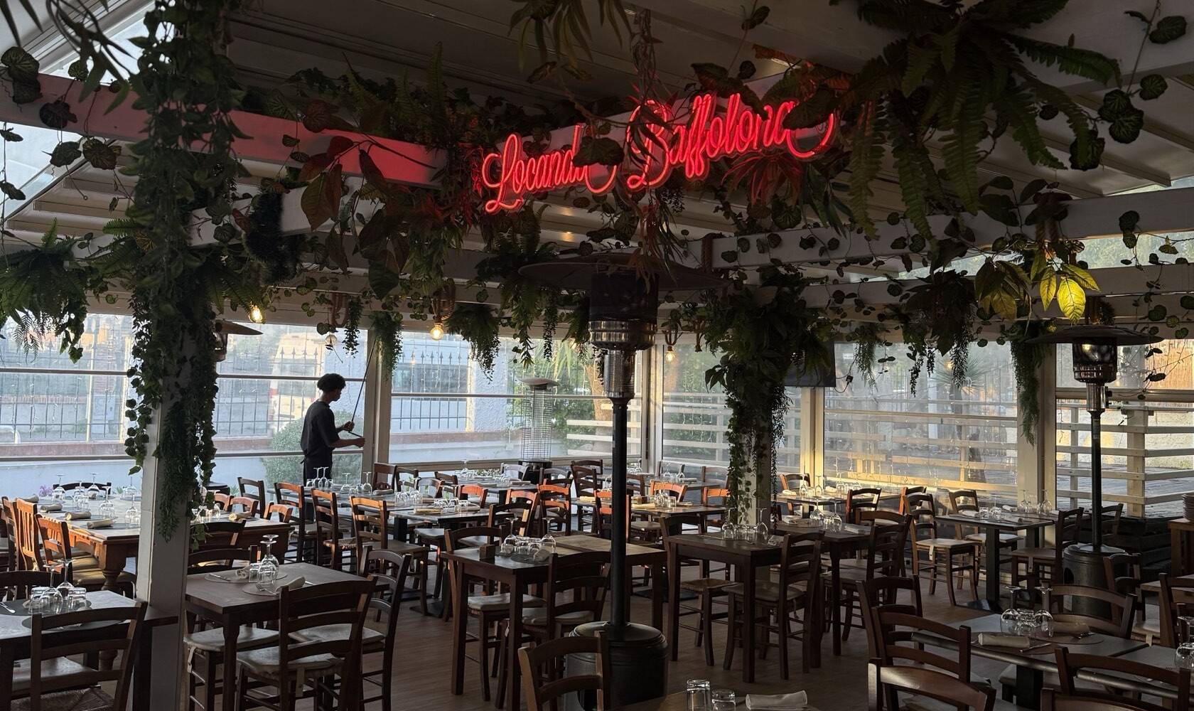 La sala veranda con l'insegna al neon Locanda Baffolona